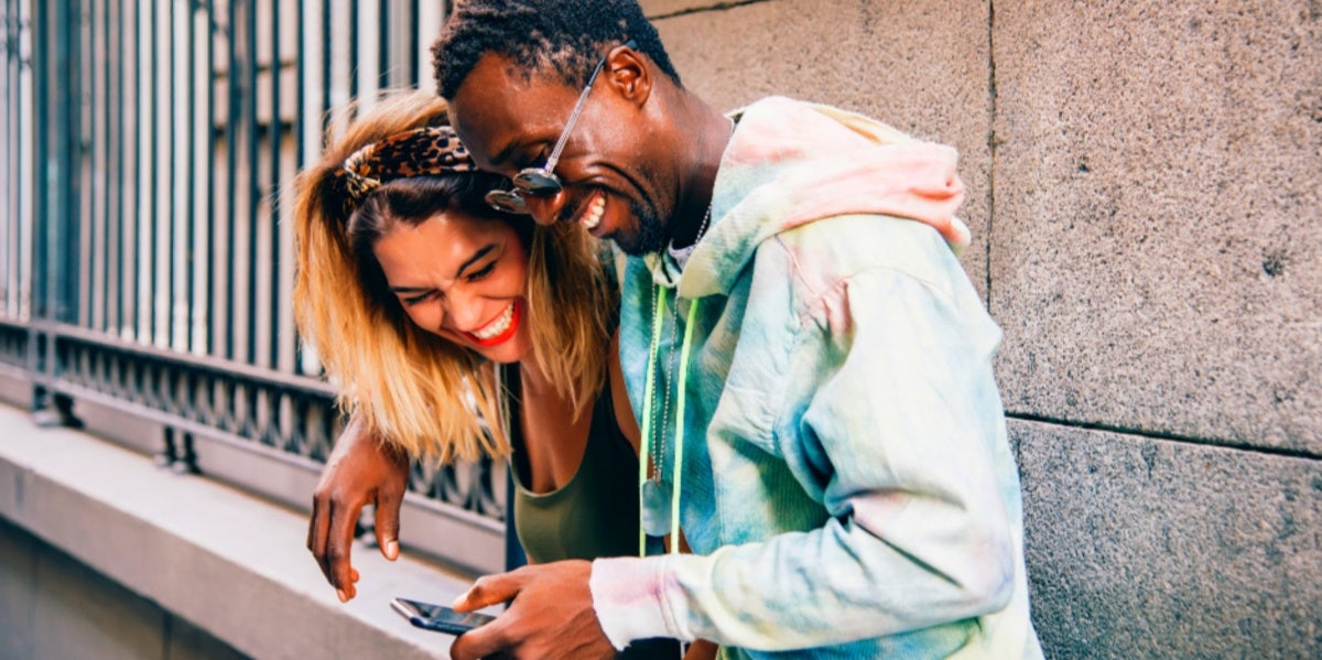 couple smiling while hugging outside on street