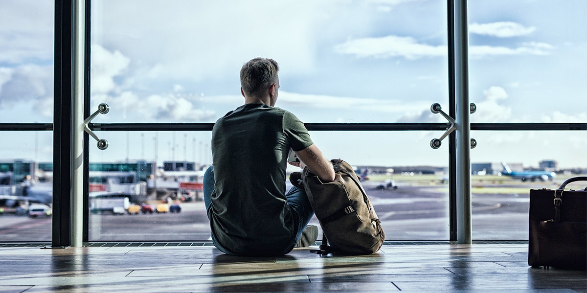 man waiting at airport by himself 
