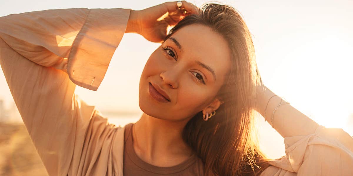 Woman on the beach with bright light behind her