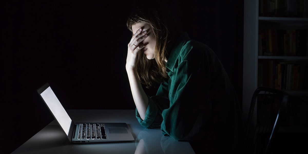 woman looking at computer in dark