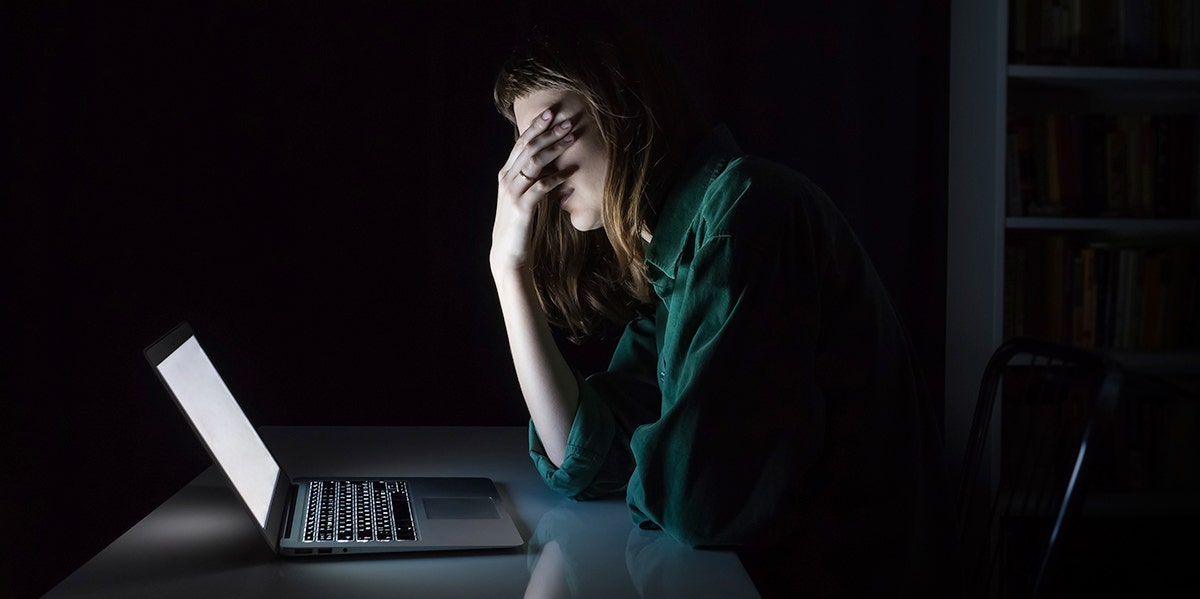 I Named My Rapist On Facebook woman looking at computer in dark