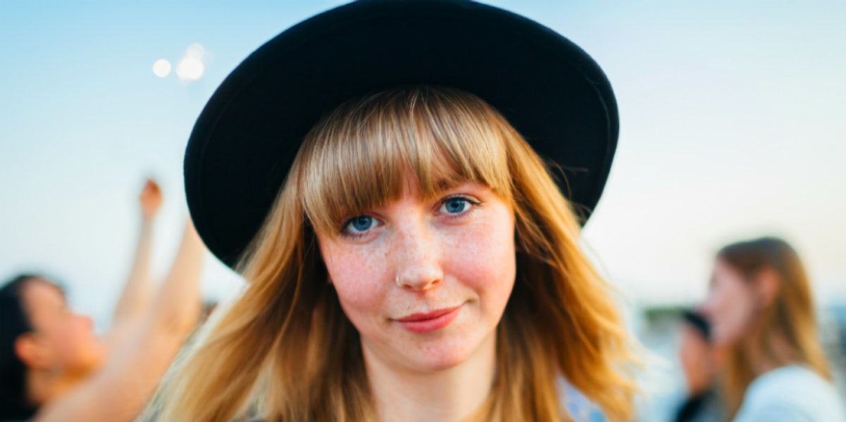 woman in black hat blond hair smiling