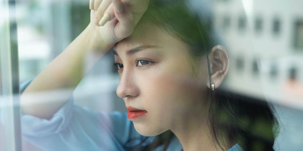 asian woman looking out window