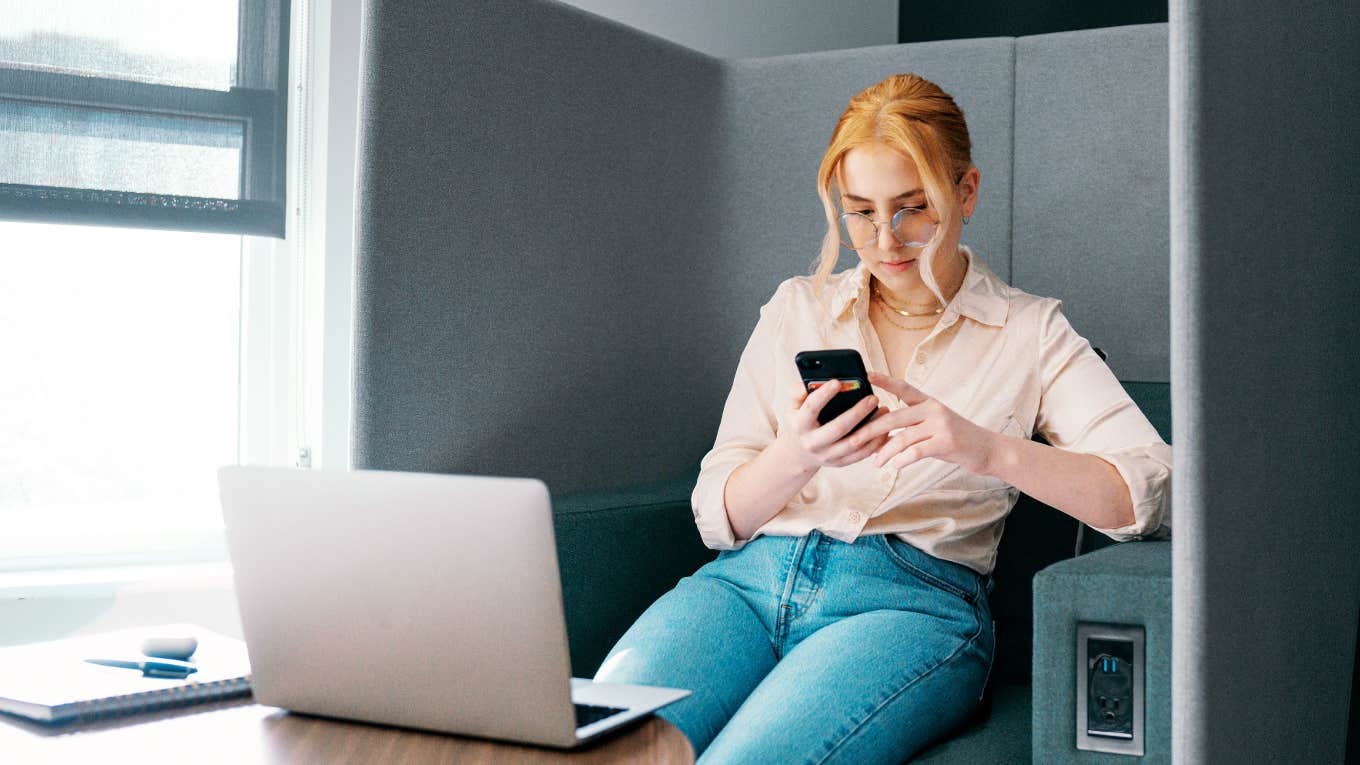 Woman working staring at her phone distracted 