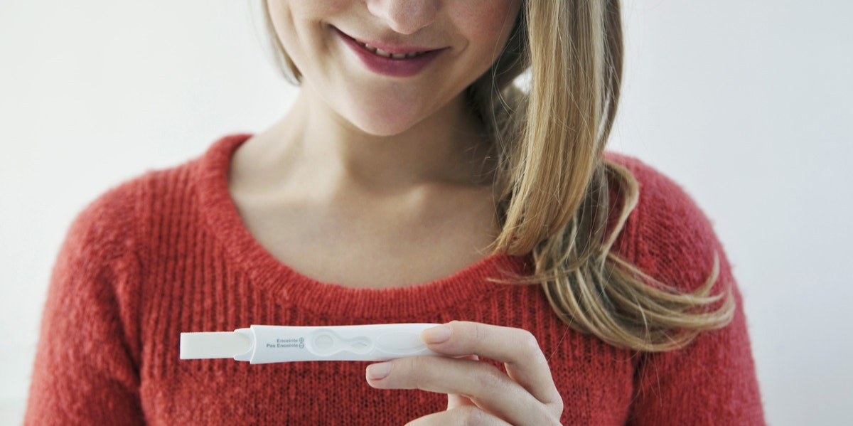 woman holding pregnancy test