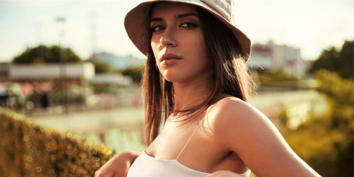 girl posing in bucket hat and crop top