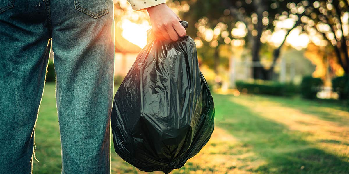 person taking trash bag out