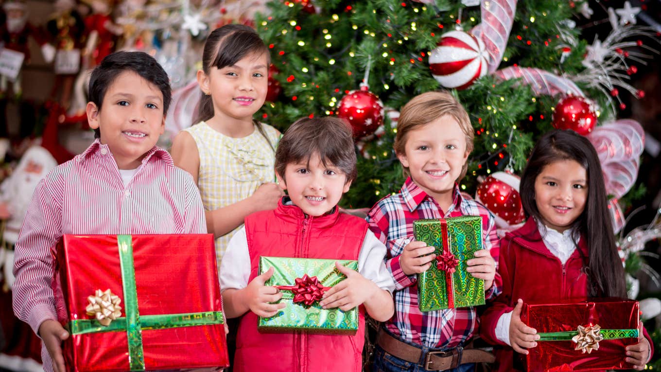 group of kids holding Christmas gifts