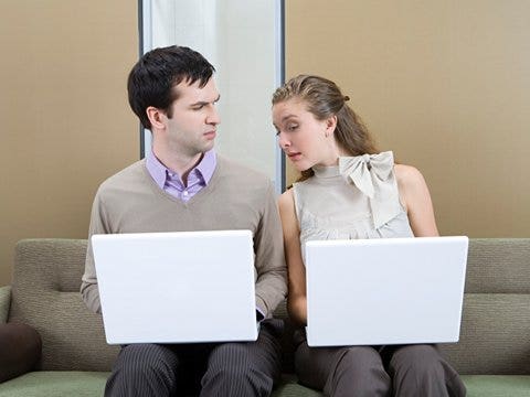couple with laptops woman snooping