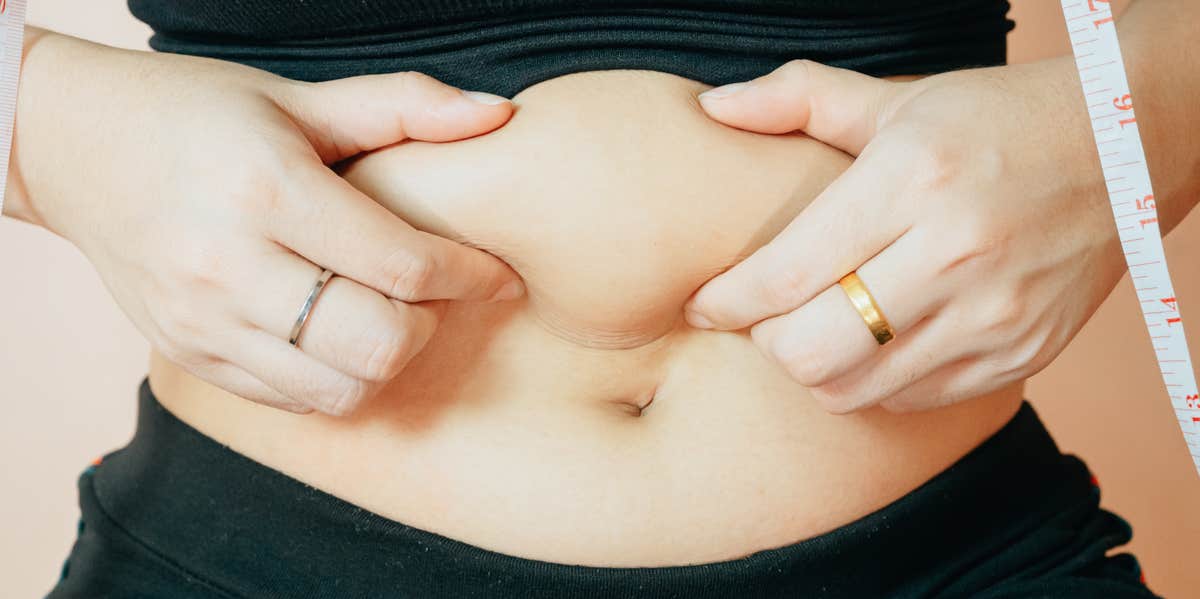 woman grabbing belly fat