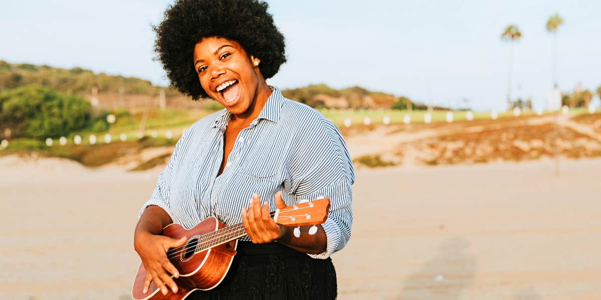 Woman on beach playing instrument