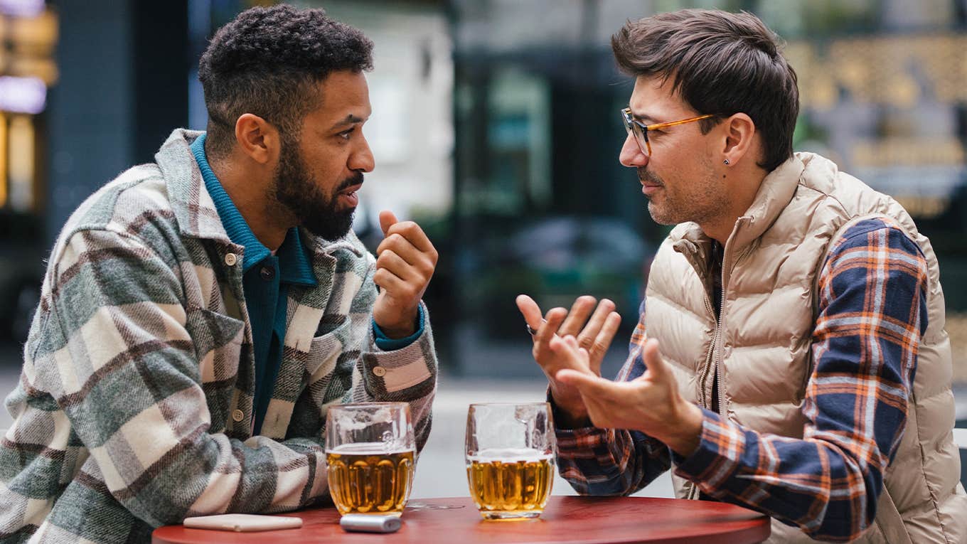 two guy friends talking and enjoying drinks
