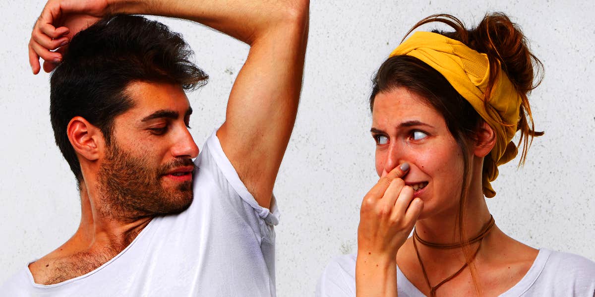 woman smelling man's armpit