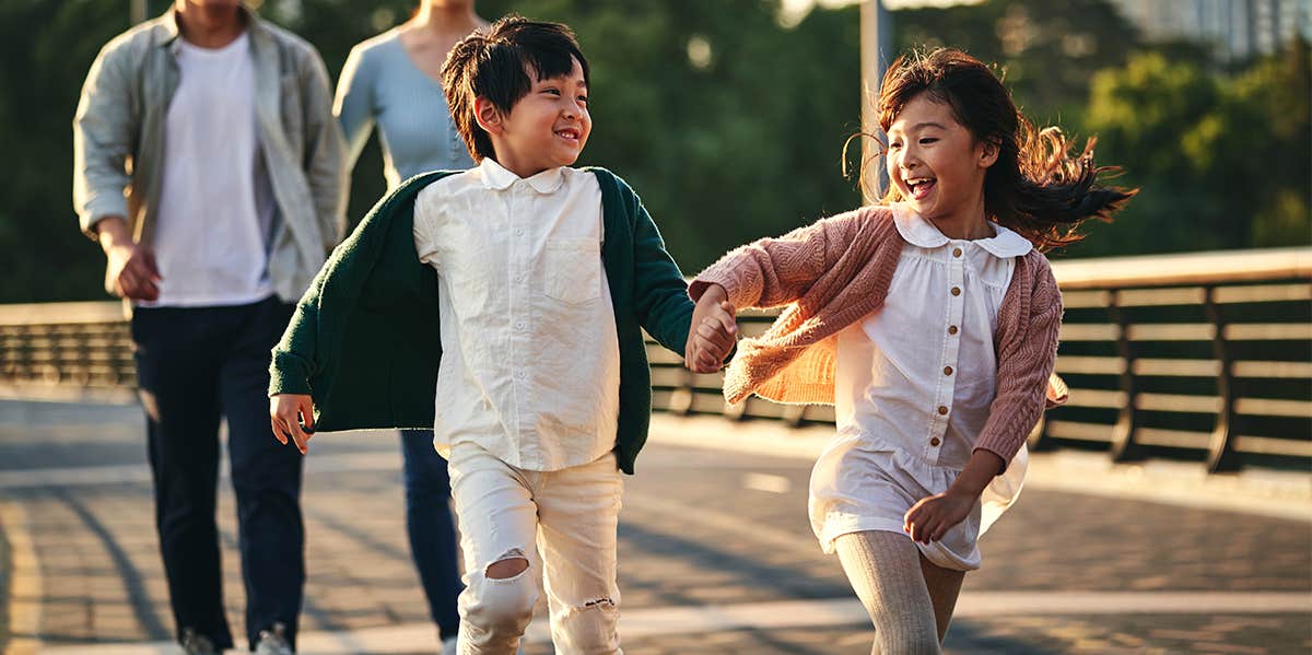 little boy and girl running and playing outside