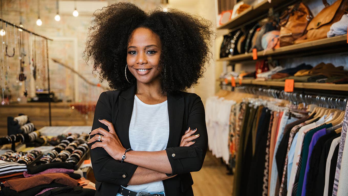 6 Subtle Attitude Changes That Can Turn Into Serious Wealth woman standing in store next to clothign racks