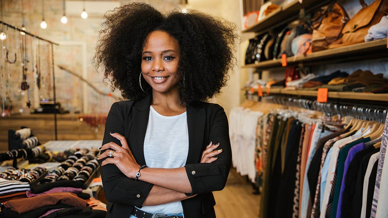 woman standing in store next to clothign racks