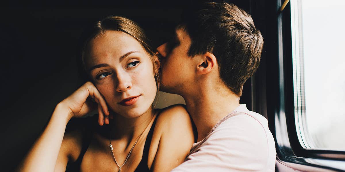 man kissing woman who seems detached