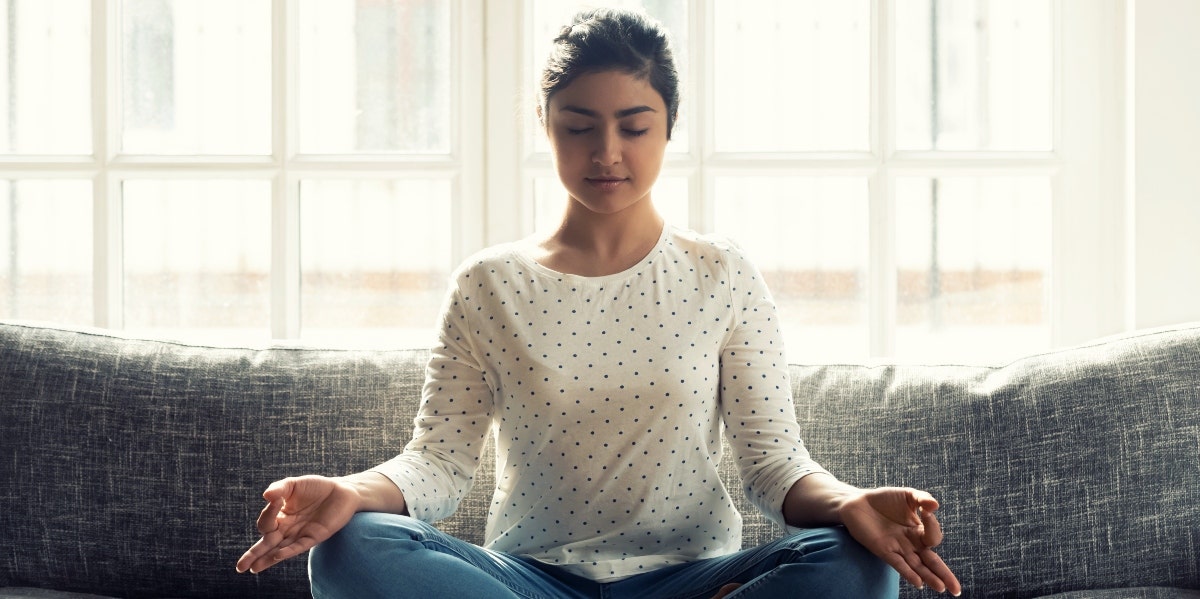 woman meditating on couch