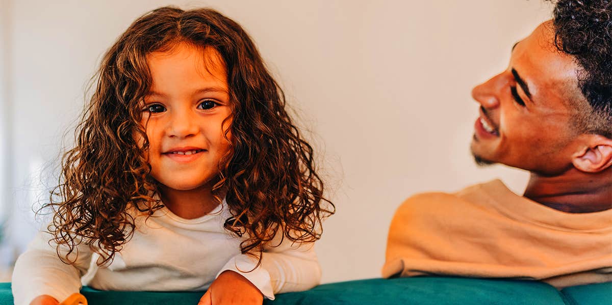 toddler girl smiling next to dad