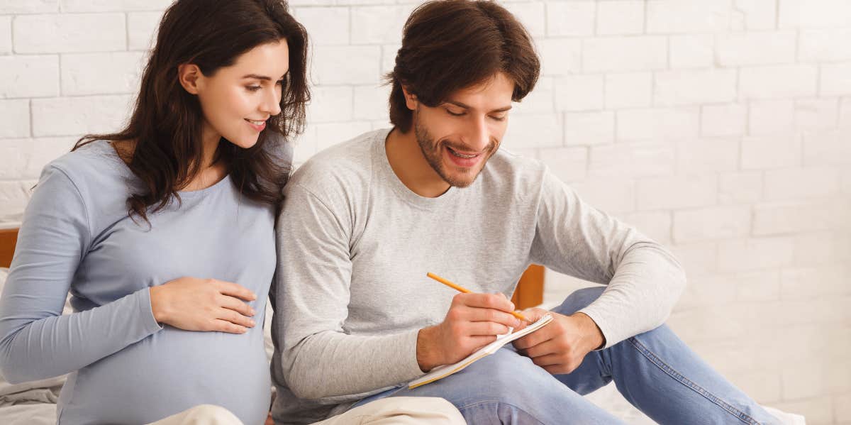 Man and woman writing baby names