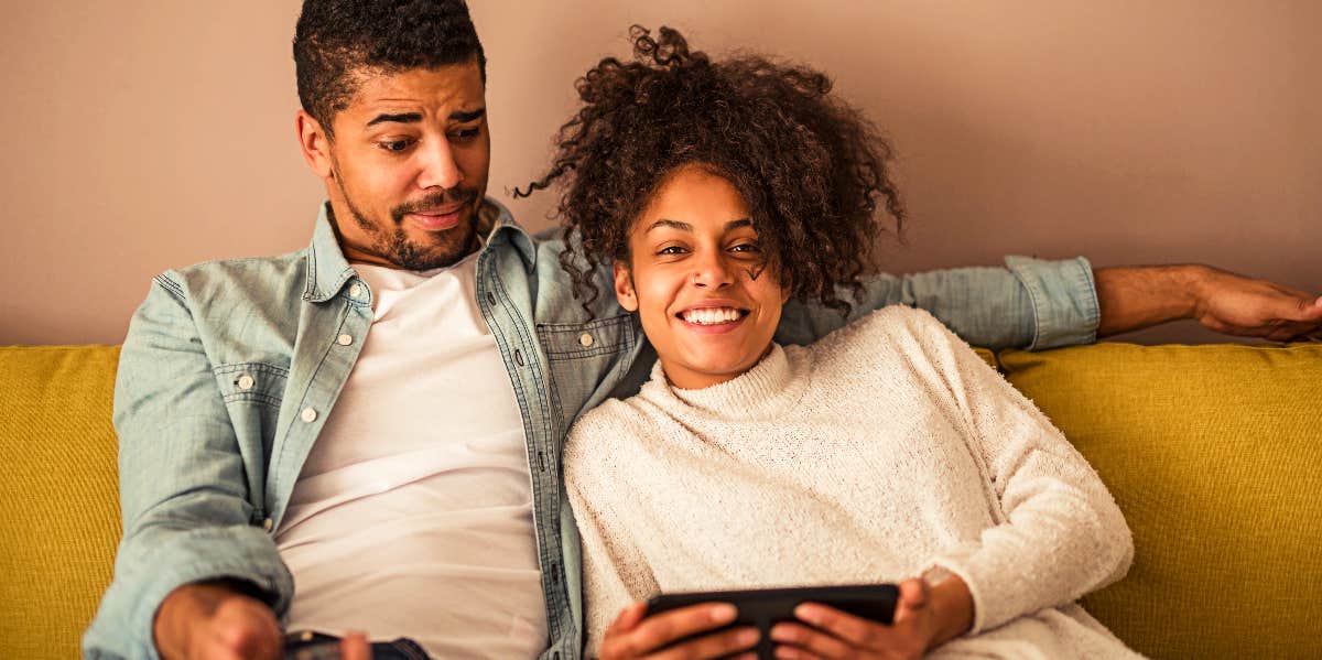 Man and woman on couch watch TV