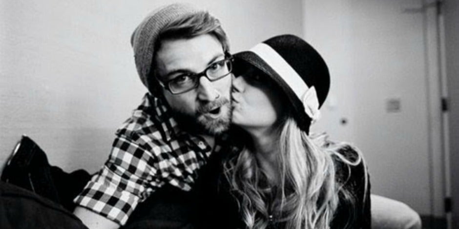 woman kissing man with beard