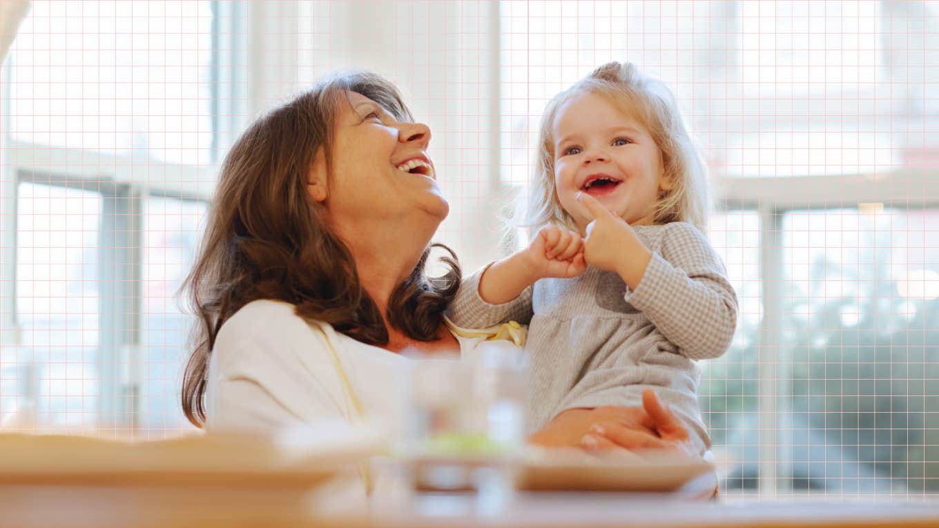 Mature new mother with her toddler laughing in the kitchen happily 