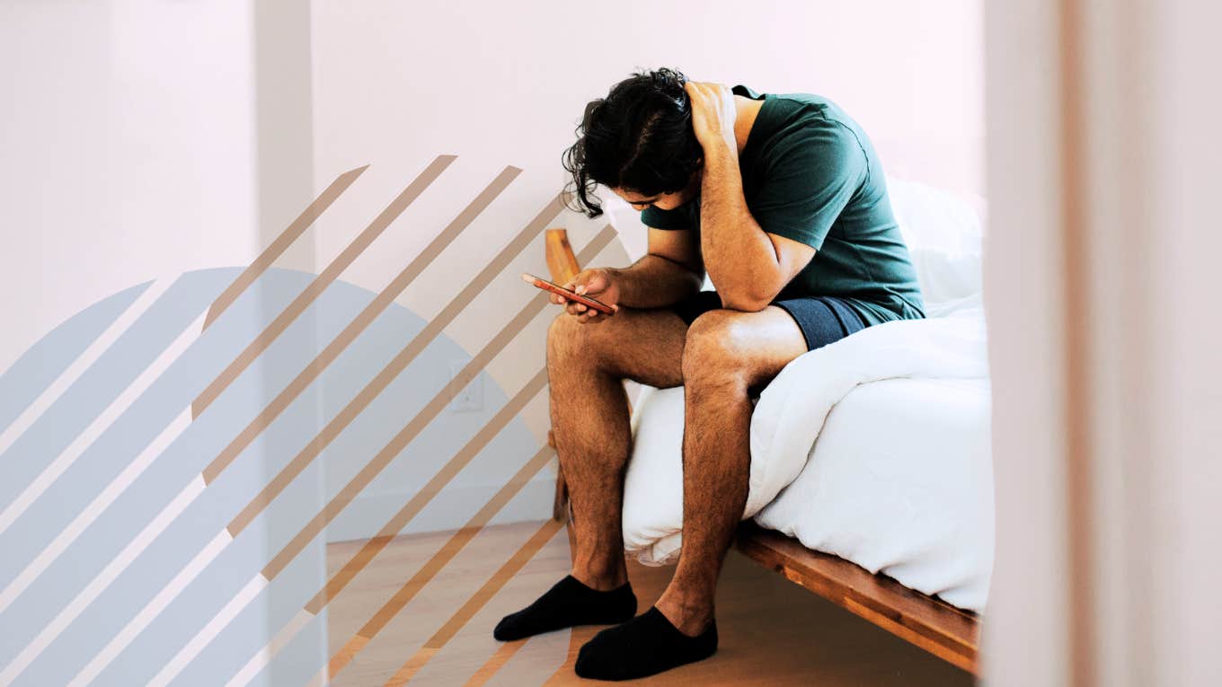 Depressed man sitting on the side of bed rubbing his head 