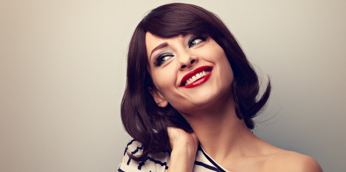 woman flipping her hair smiling with red lipstick