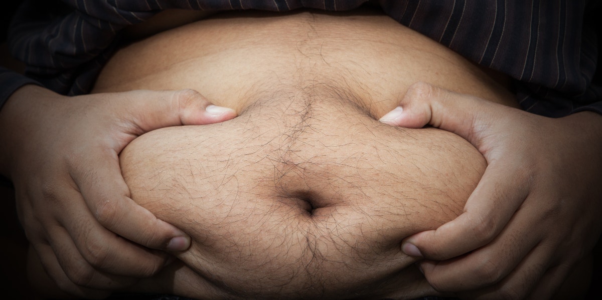 photo of man clutching his big belly