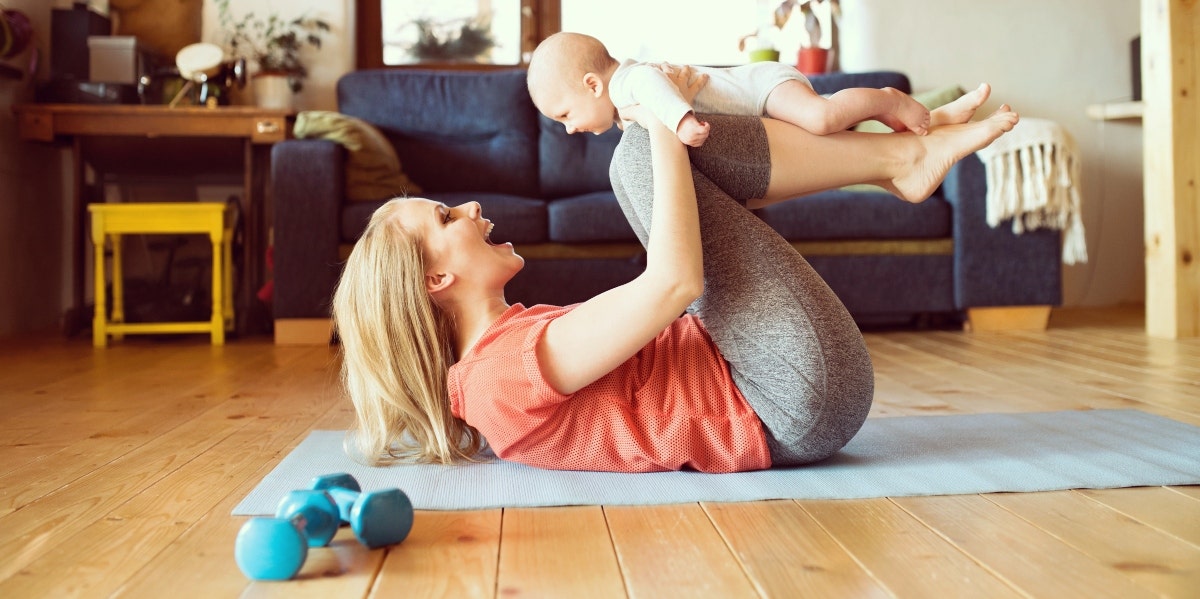 woman working out at home with baby
