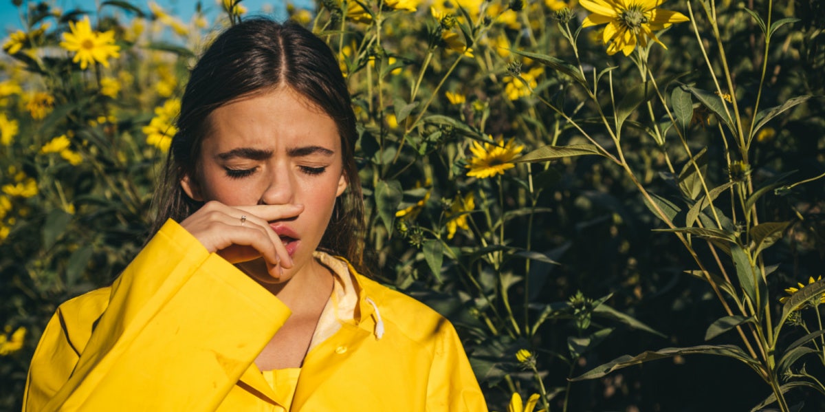 woman in field of flowers with seasonal allergies