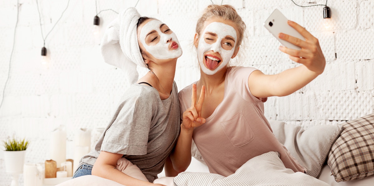 women with face masks on taking a selfie