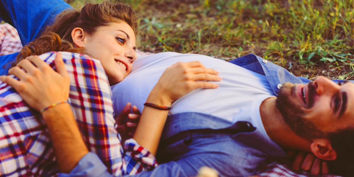couple in flannel laying on each other in the grass