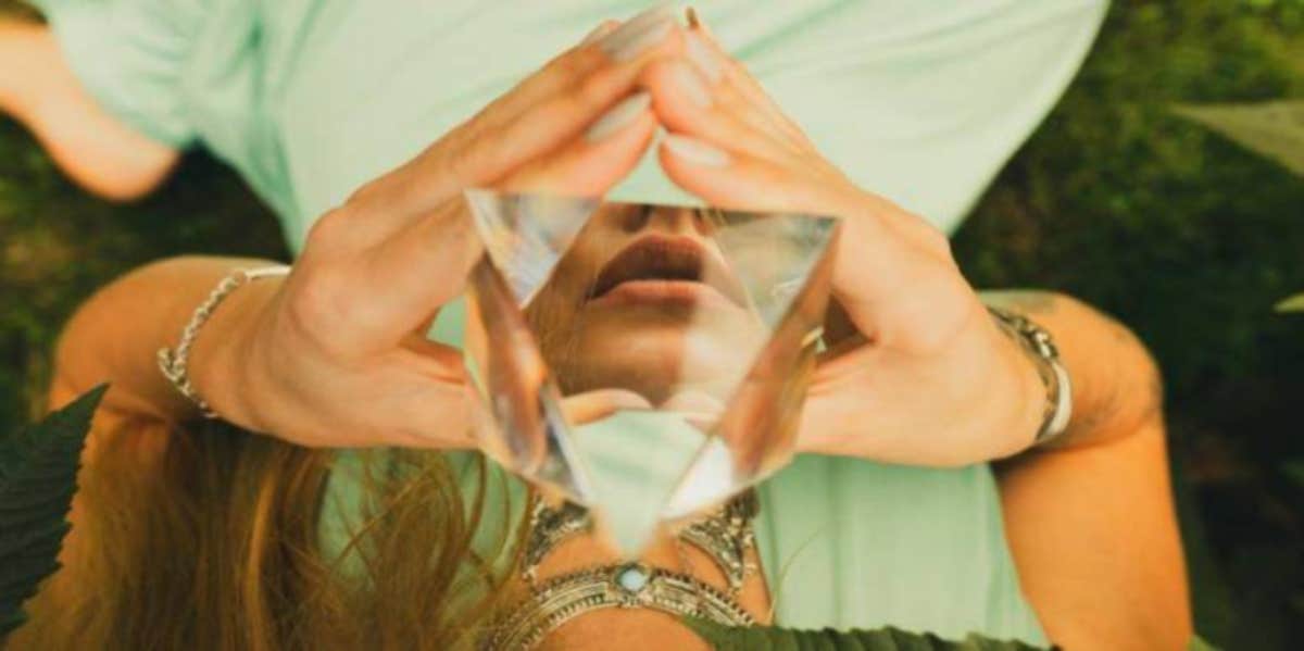woman holding clear crystal