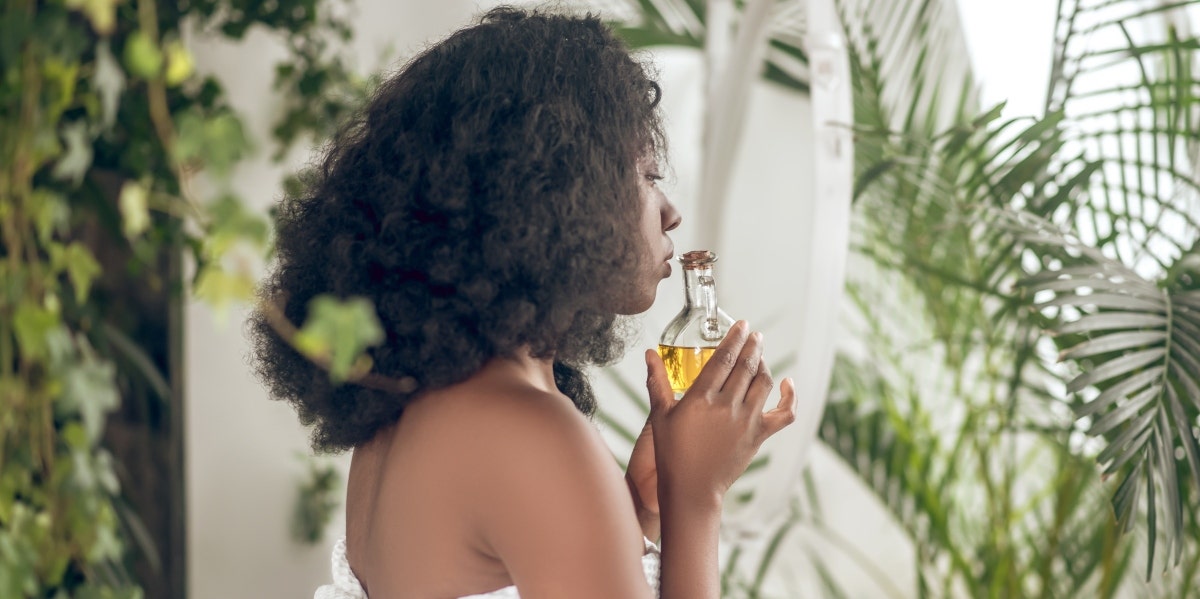 woman holding a bottle of essential oil