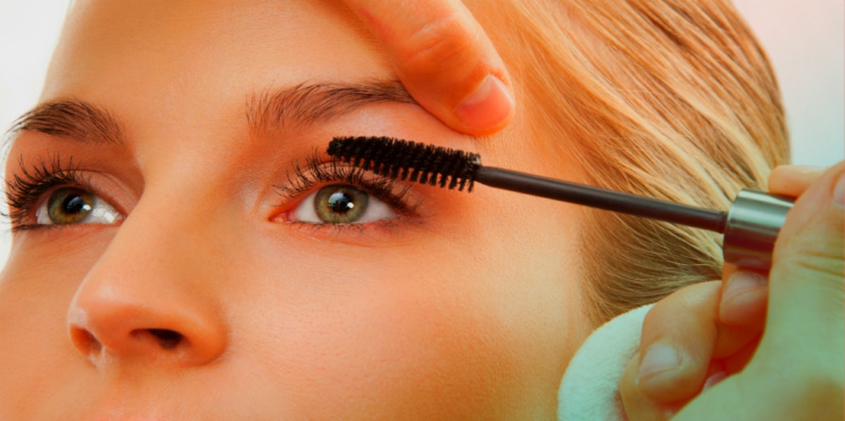 woman putting on mascara