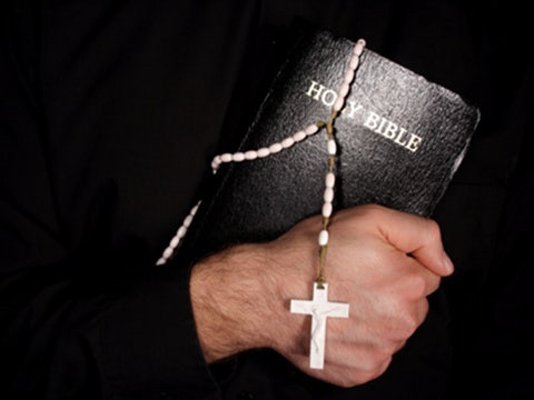 priest holding Bible