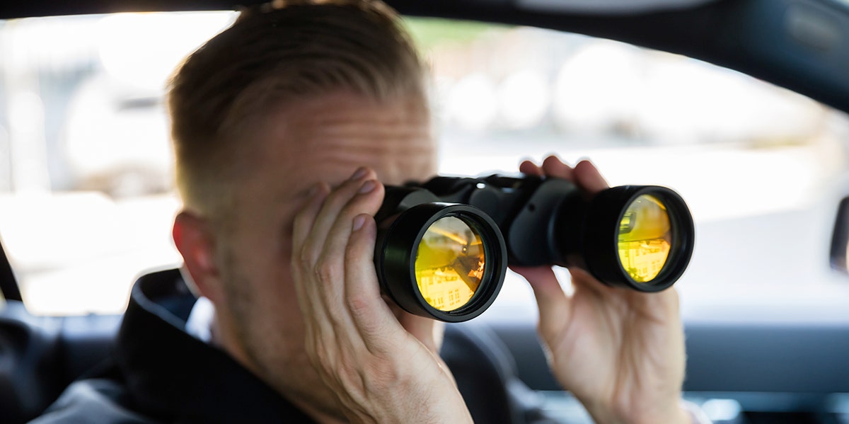 man in a car with binoculars