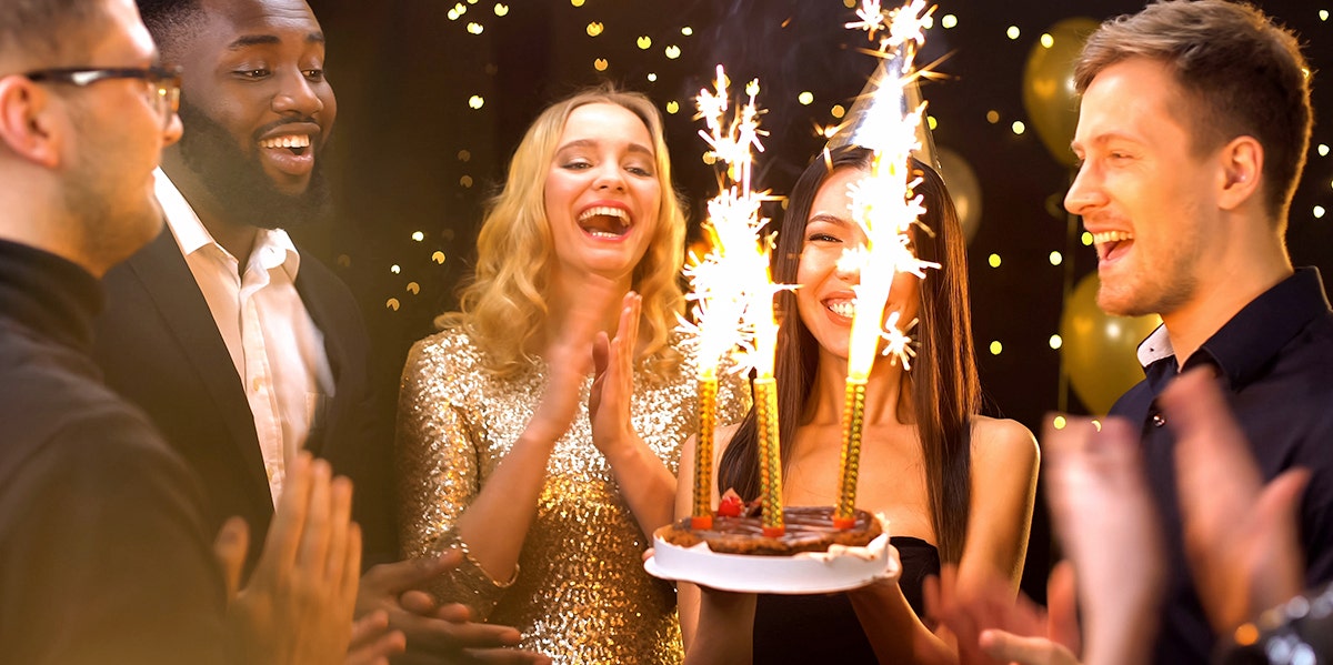 friends celebrating birthday with cake sparklers