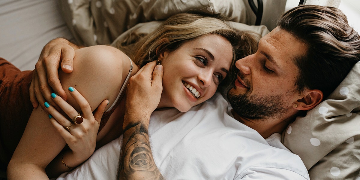 couple smiling hugging in bed