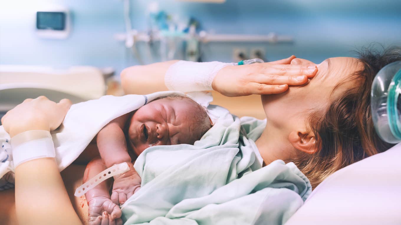 mom hugging her newborn baby after delivery.