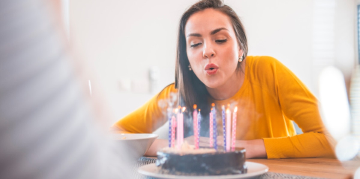 woman blowing out candles on a cake