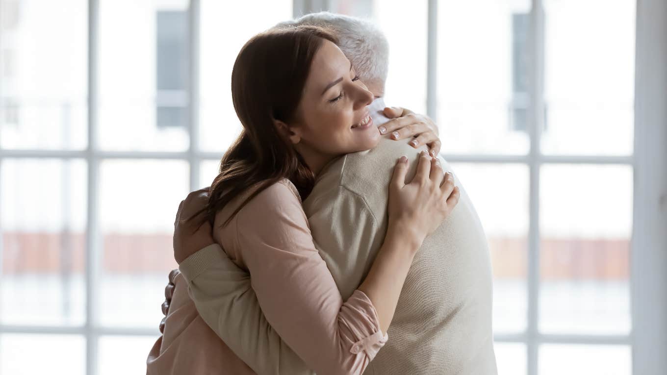 old man hugging young woman