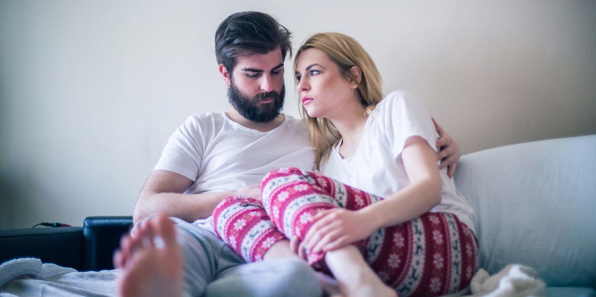 couple arguing on couch cuddling