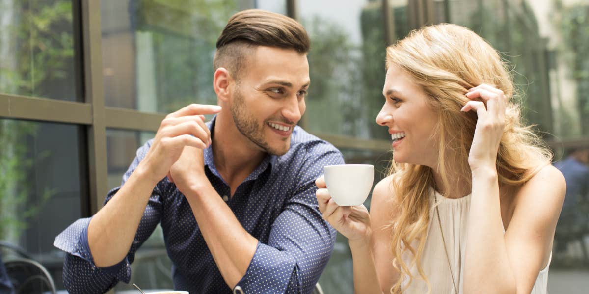 man using body language to show his interest in woman drinking cup of coffee