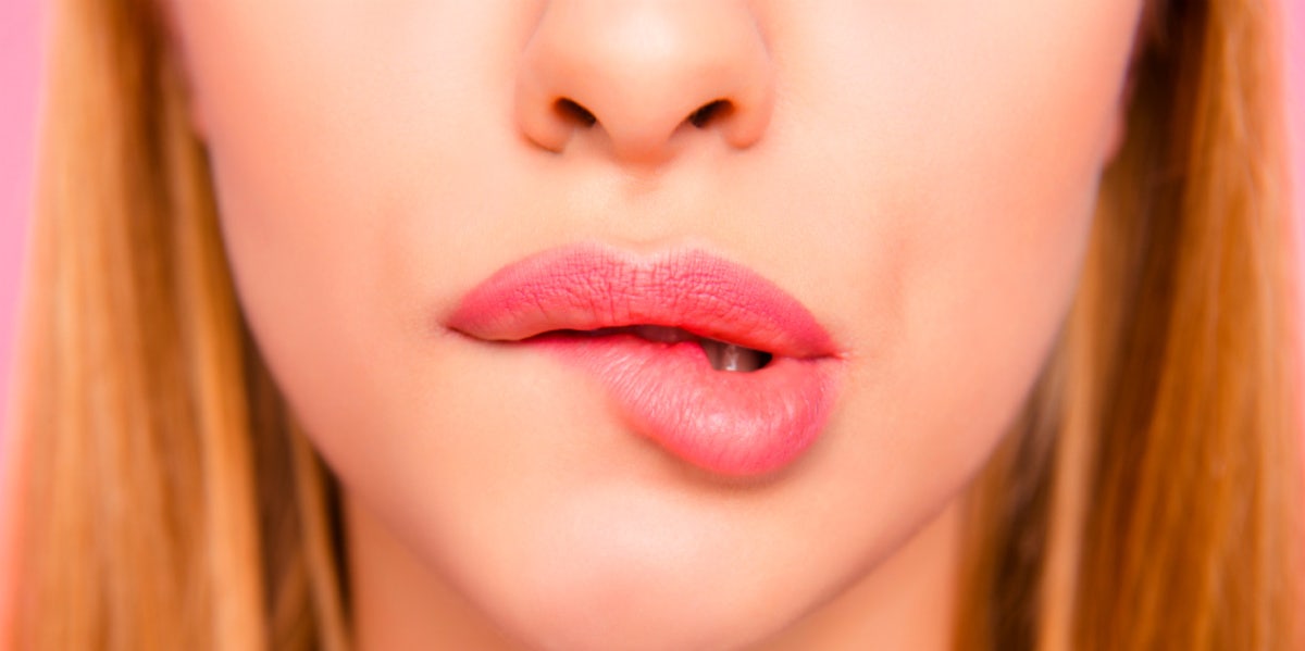 What It Means If Your Body Aches Or You're Sore After Sex woman biting lip