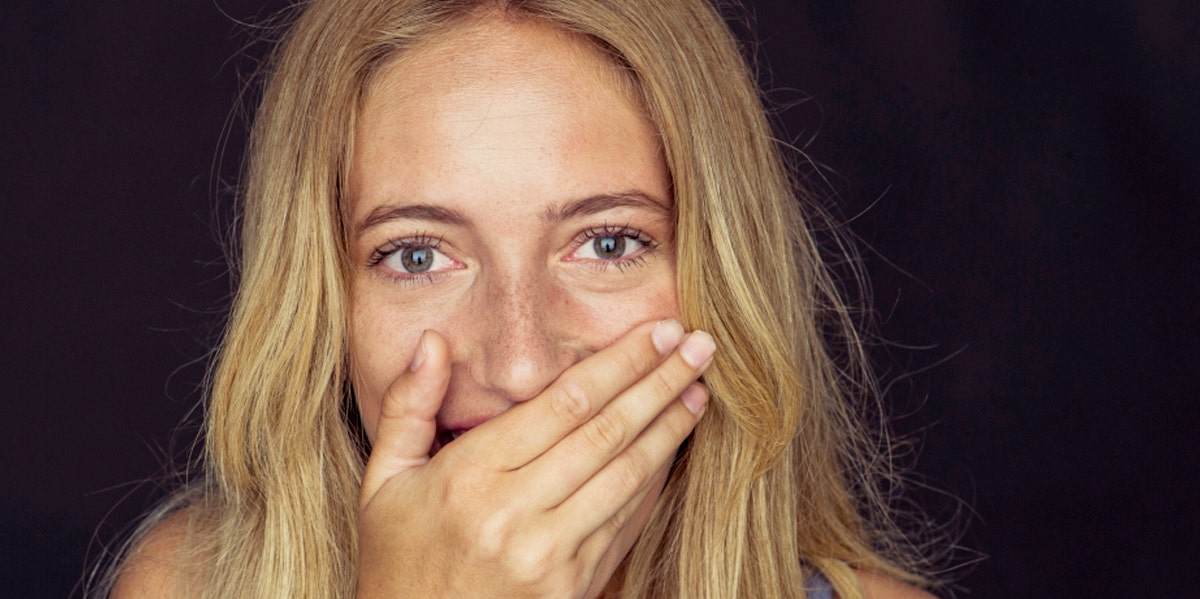 woman with hand over mouth