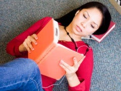 woman reading book lying down