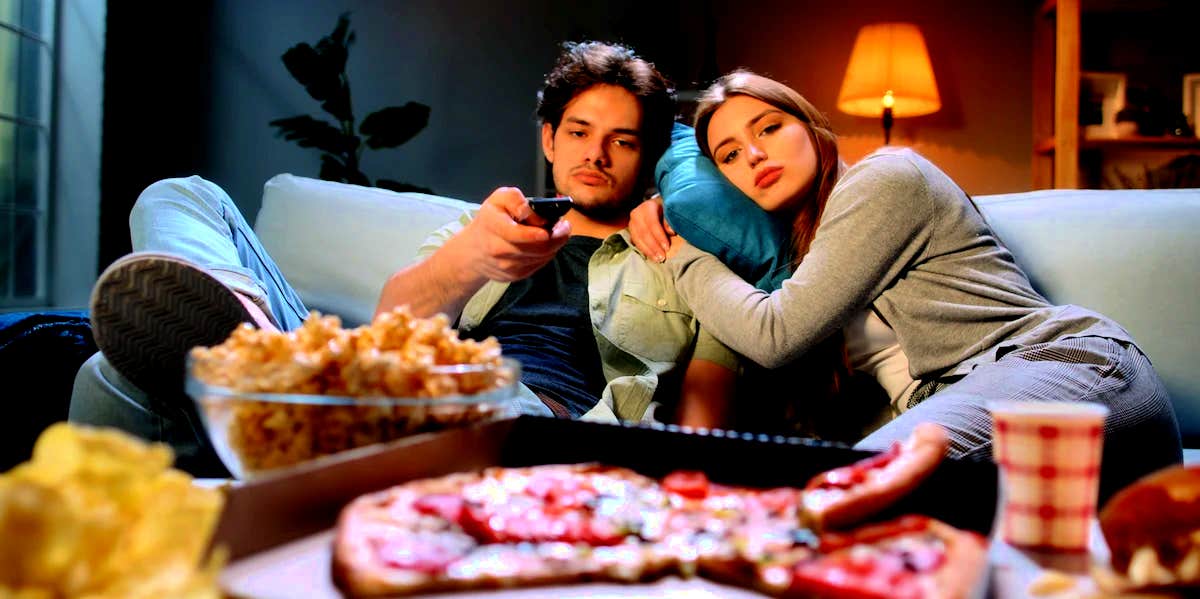 7 Ways To Deal With Boredom In Your Marriage (Before It's Too Late) couple sitting on couch together bored